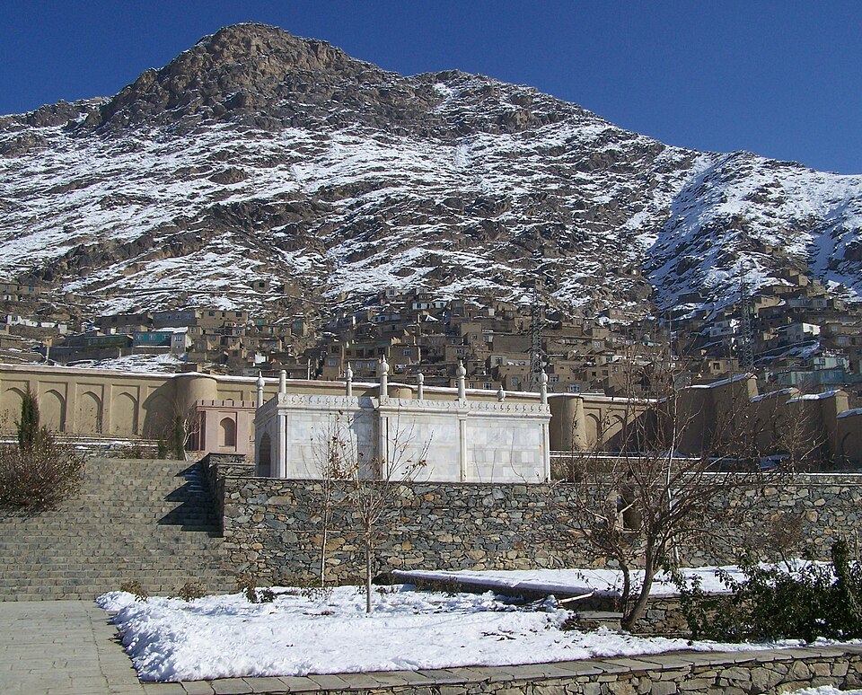 Los jardines de Babur en Kabul con muros y montañas nevadas detrás