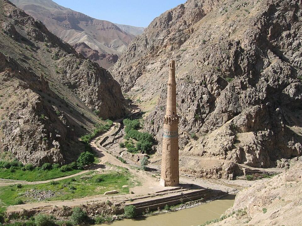 El minarete de Jam de ladrillo en el fondo de un valle rodeado de montañas