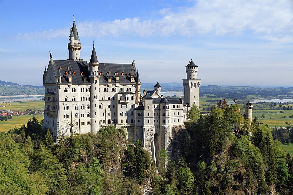 El castillo de Neuschwanstein sobre el bosque con valles detrás