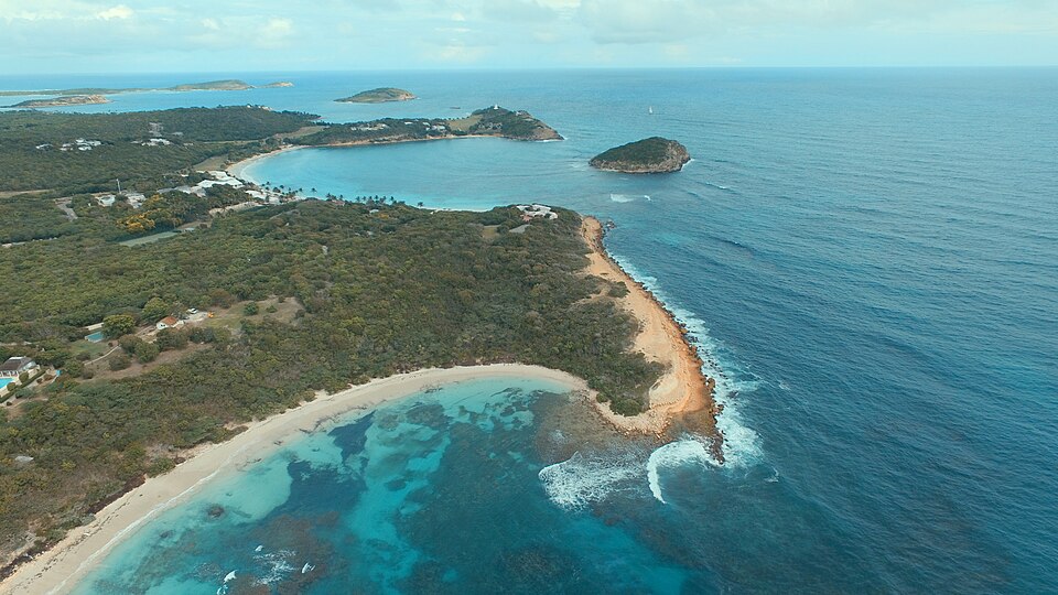 Vista aérea de Half Moon Bay en forma de media luna con agua turquesa