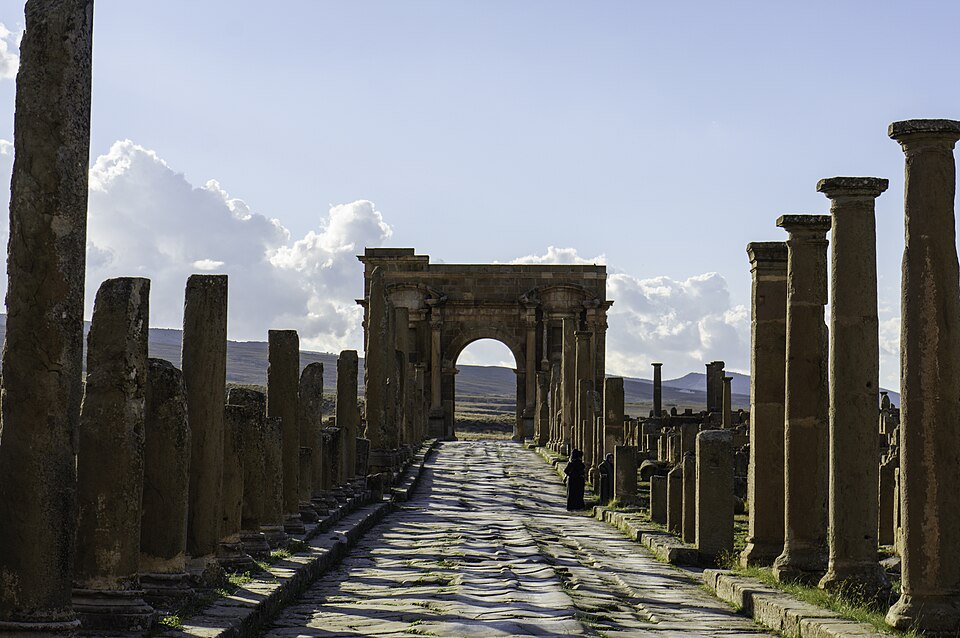 Calle romana empedrada con columnas que lleva al Arco de Trajano en Timgad
