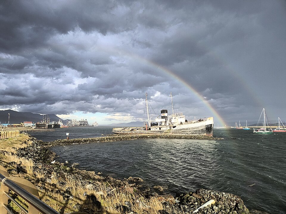 Costa de Ushuaia sobre el canal Beagle con un barco y un arcoíris