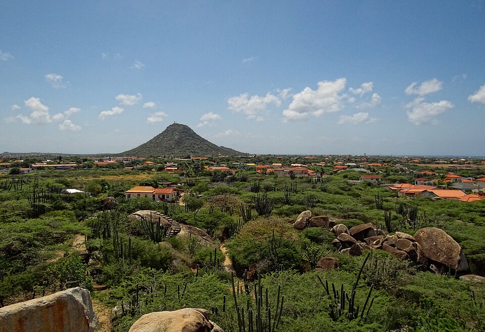 El cerro cónico Hooiberg sobre un paisaje de cactus y rocas