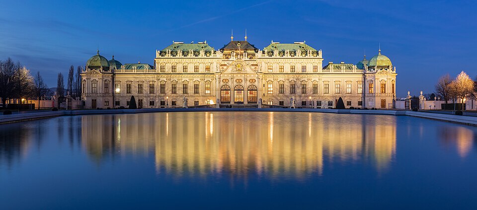 El palacio Belvedere iluminado y reflejado en el estanque