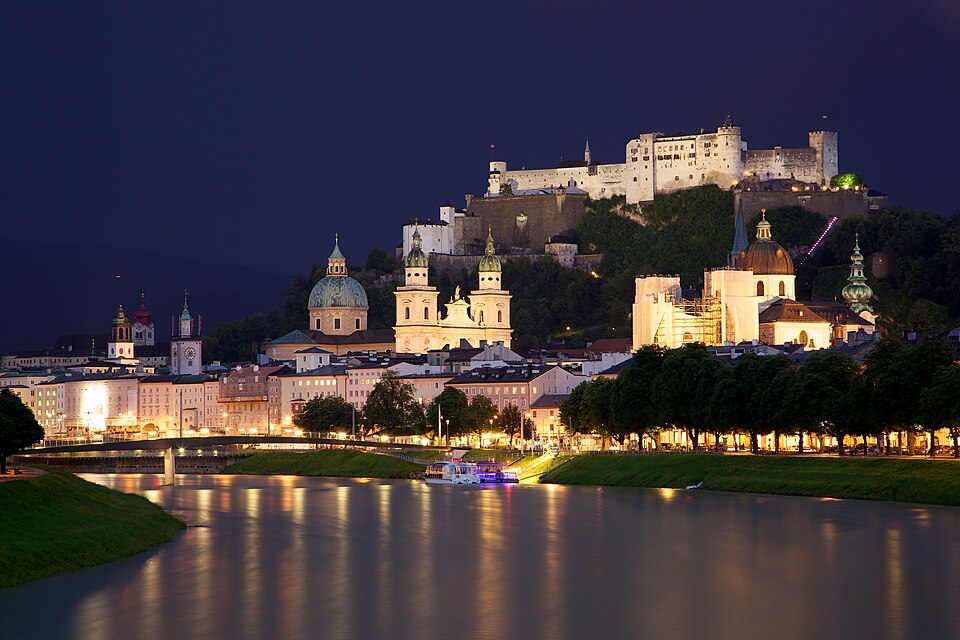 El centro de Salzburgo y su fortaleza iluminados de noche junto al río