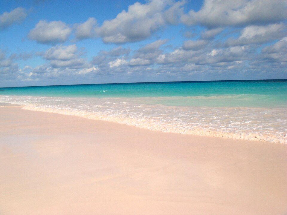 Arena rosada de Pink Sands Beach frente a un mar turquesa