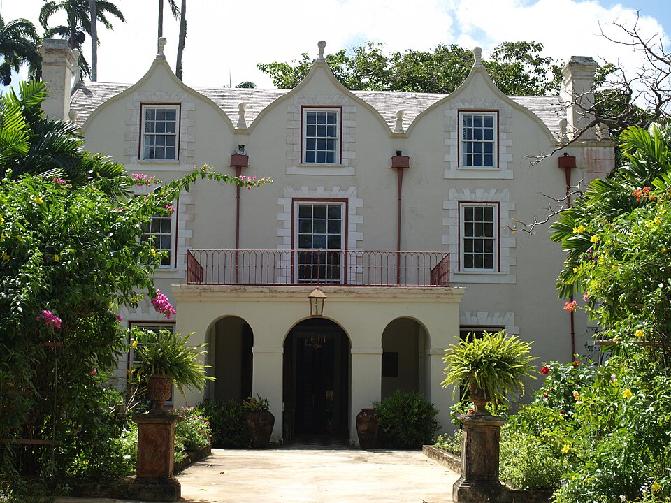 Fachada blanca con frontones curvos de la casa St Nicholas Abbey entre plantas