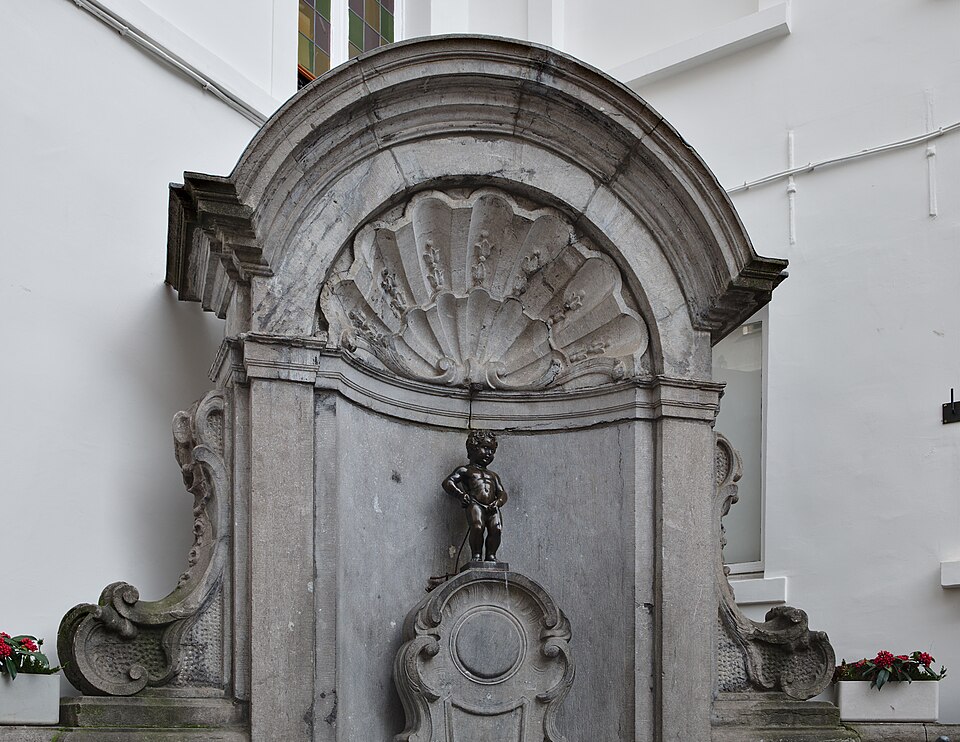 La estatua del Manneken Pis en su fuente de piedra