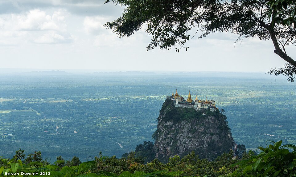 El monasterio sobre el peñón de Taung Kalat en medio de una llanura verde