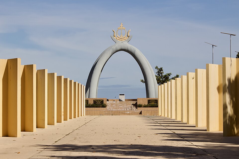 El arco del monumento del Barril Mil Millones al final de un camino con columnas