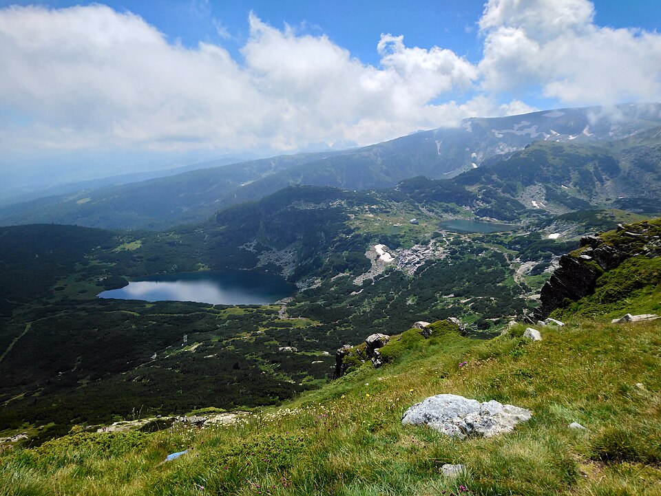 Un lago glaciar en las montañas de Rila entre praderas verdes