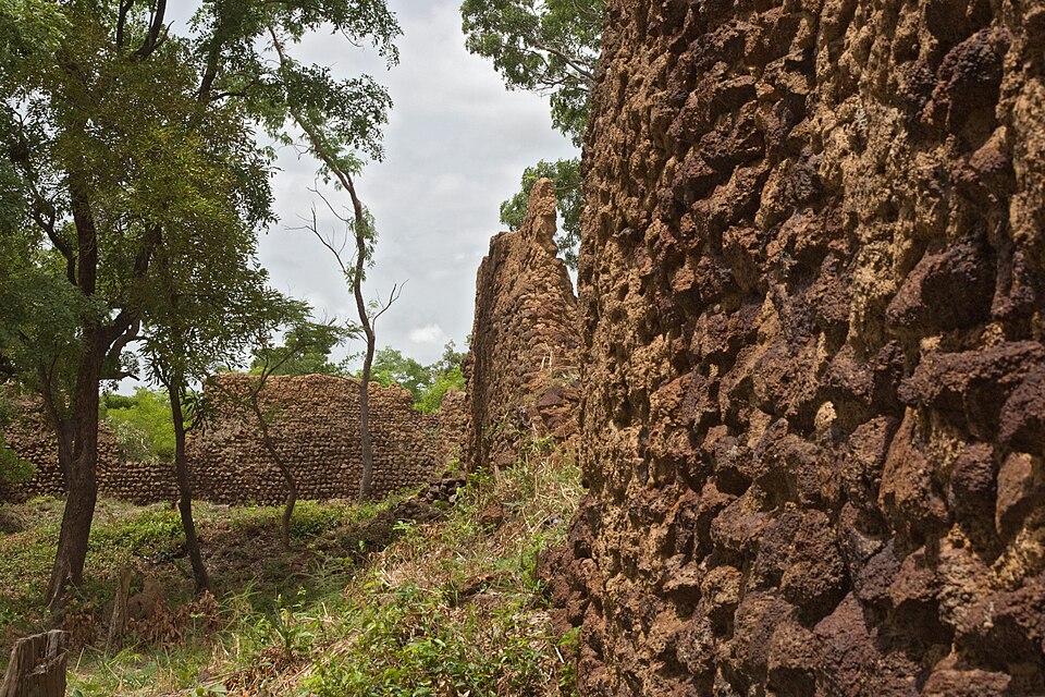 Restos de muros de piedra de las ruinas de Loropéni entre árboles