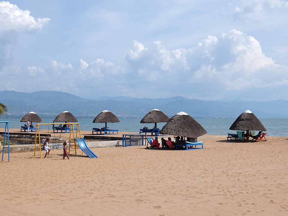 Playa de arena con sombrillas de paja a orillas del lago en Bujumbura