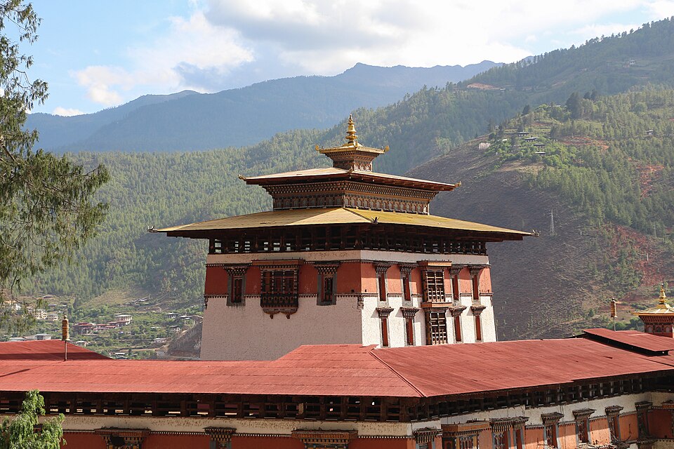 La torre central del dzong de Rinpung con techos rojos y montañas