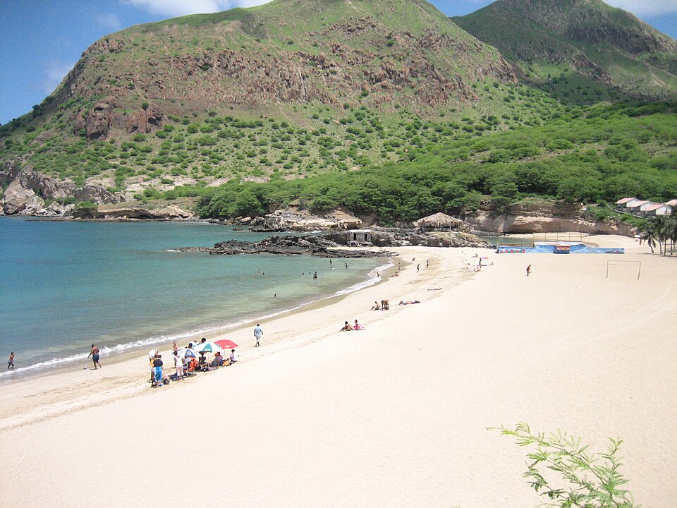 Playa de arena blanca en una bahía rodeada de montañas en Tarrafal
