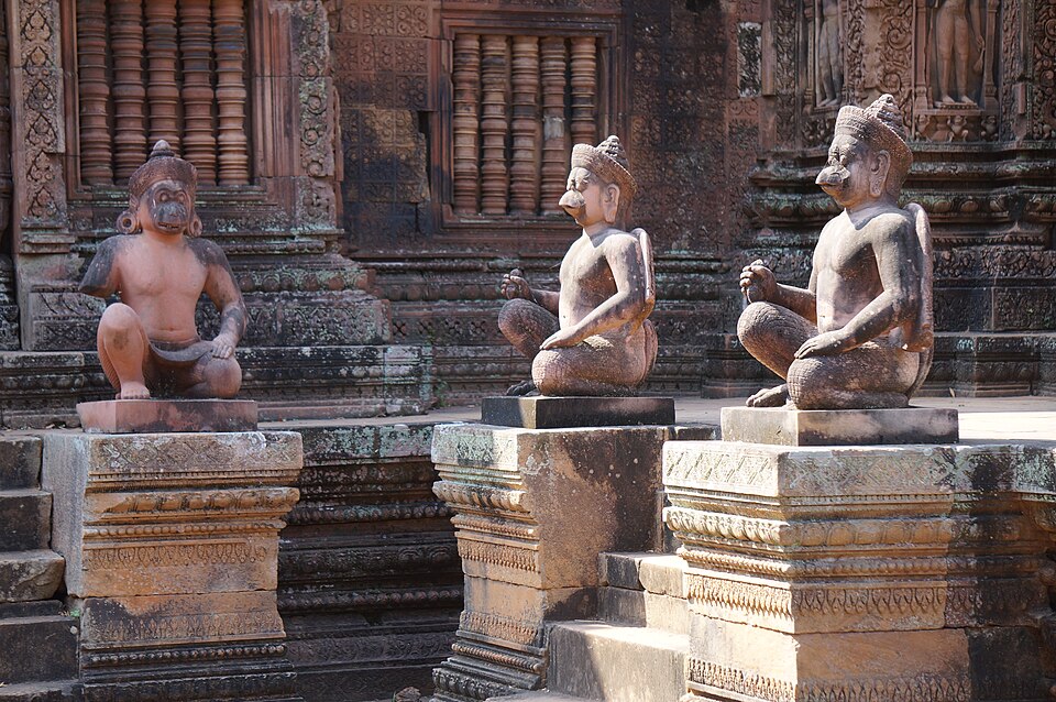 Estatuas de guardianes con cabeza de mono frente al templo rosado de Banteay Srei