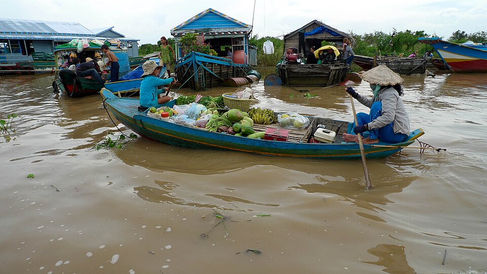 Mujeres en una lancha cargada de frutas en un pueblo flotante del Tonlé Sap