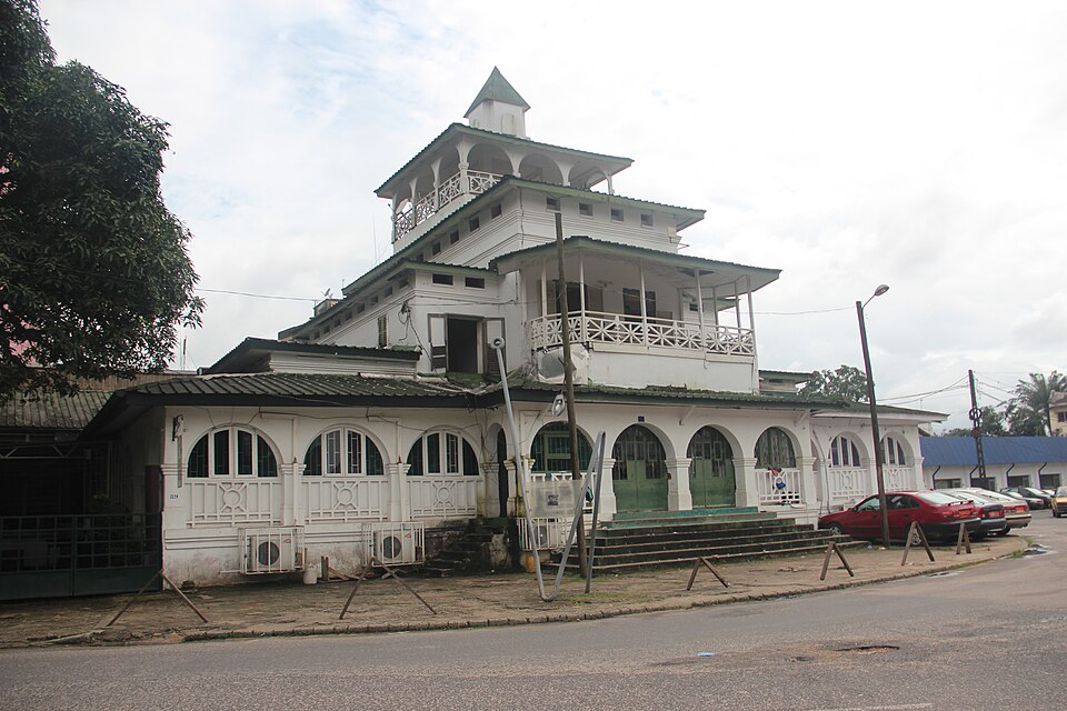 Edificio blanco de varios pisos con torre de la Pagoda de Duala