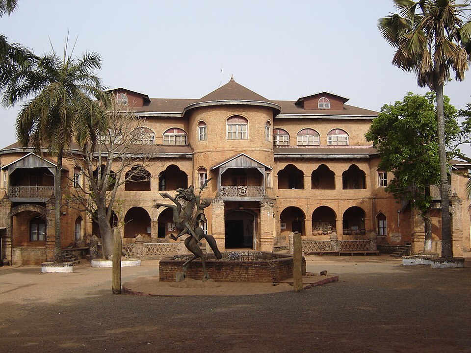 Fachada del palacio del sultán de Foumban con arcos y palmeras