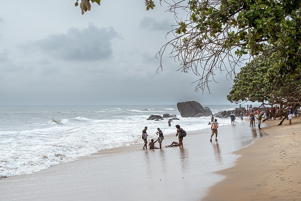 Playa de Kribi con rocas en el mar y gente bañándose
