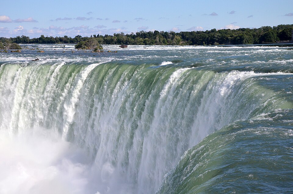 El borde verde de la catarata de la Herradura del Niágara cayendo en una nube de agua