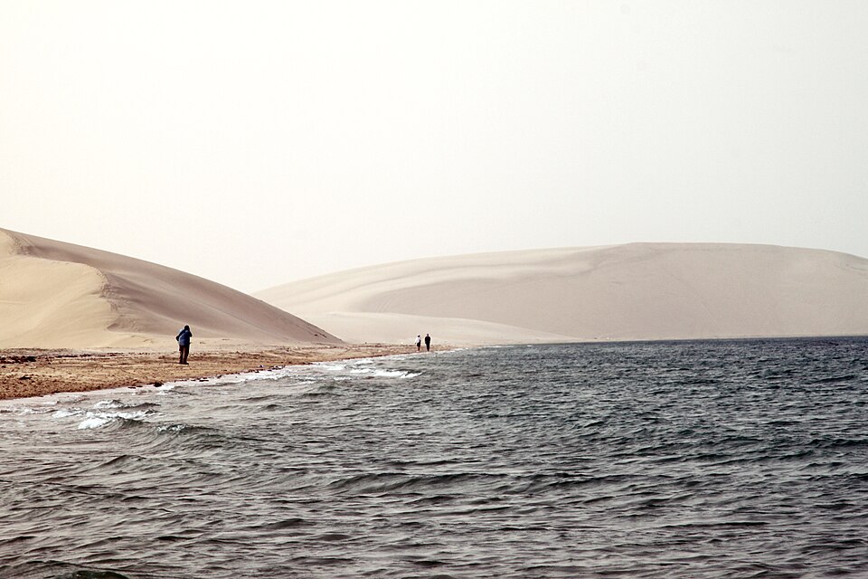 Grandes dunas de arena que bajan hasta el agua en Khor Al Adaid