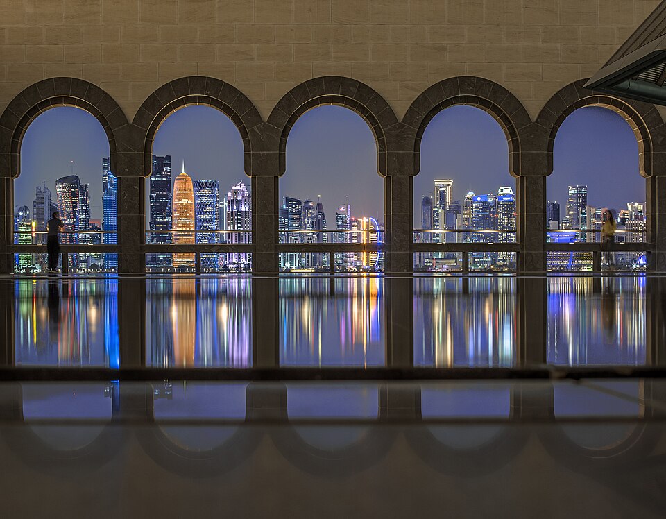 Los rascacielos de Doha iluminados vistos a través de los arcos del Museo de Arte Islámico