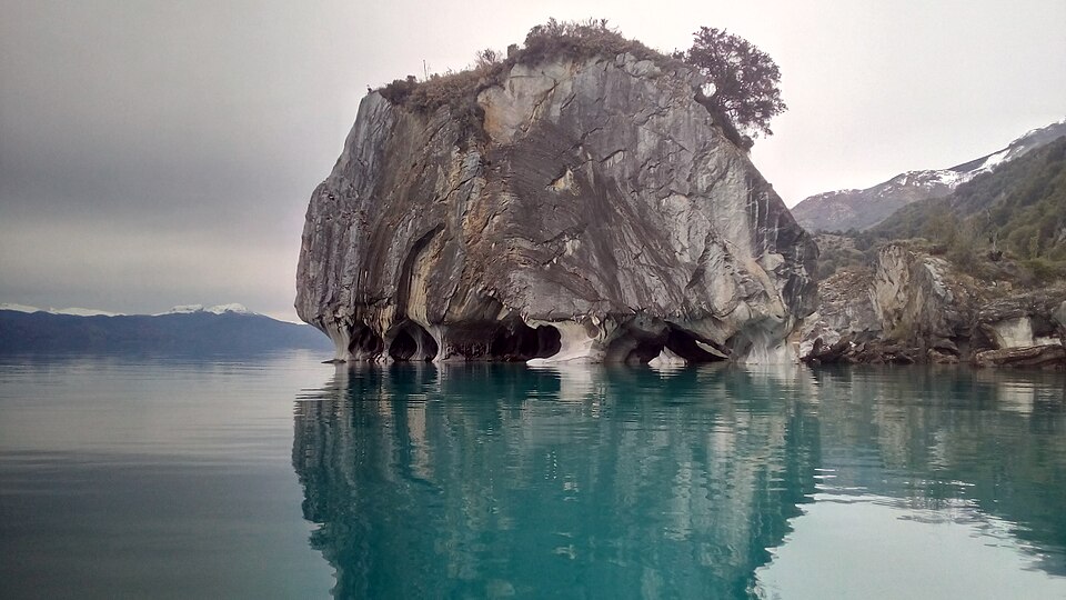 Roca de mármol con cuevas reflejada en el agua turquesa del lago General Carrera