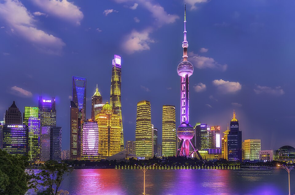Los rascacielos iluminados de Pudong reflejados en el río de noche