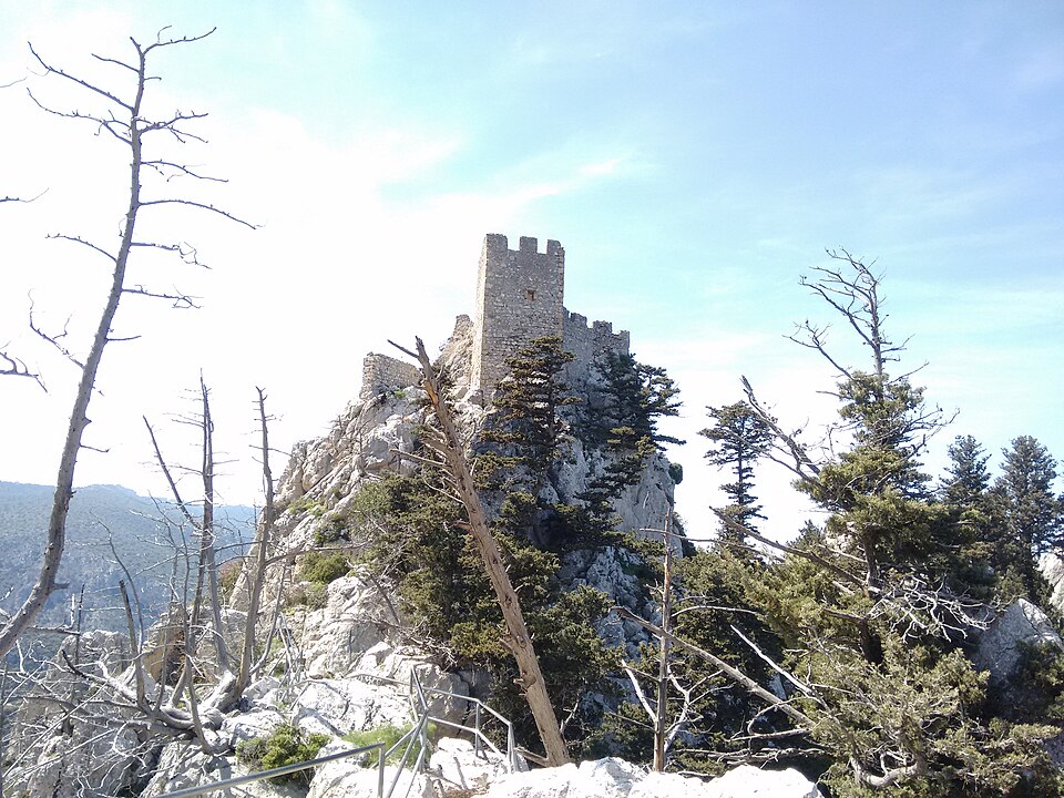 Las torres del castillo de San Hilarión sobre un peñasco entre pinos