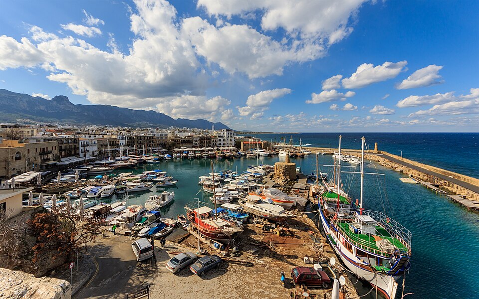 El puerto de Kyrenia con barcos de madera y montañas al fondo