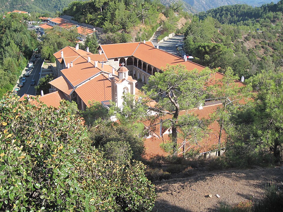 El monasterio de Kykkos con techos rojos entre pinos, visto desde lo alto