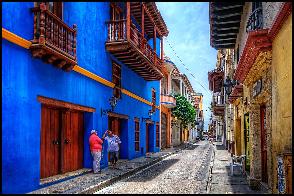 Calle colonial de Cartagena con casas azules y amarillas y balcones de madera