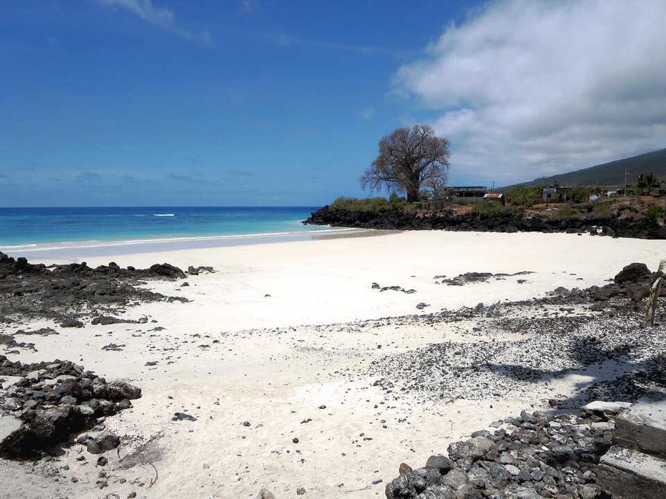 Playa de arena blanca con rocas de lava negra en Chomoni