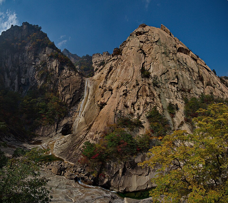 Una gran pared de granito con una cascada en las Montañas de Diamante