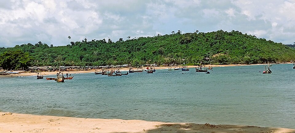 Piraguas de pescadores en una bahía con una colina de selva en Monogaga