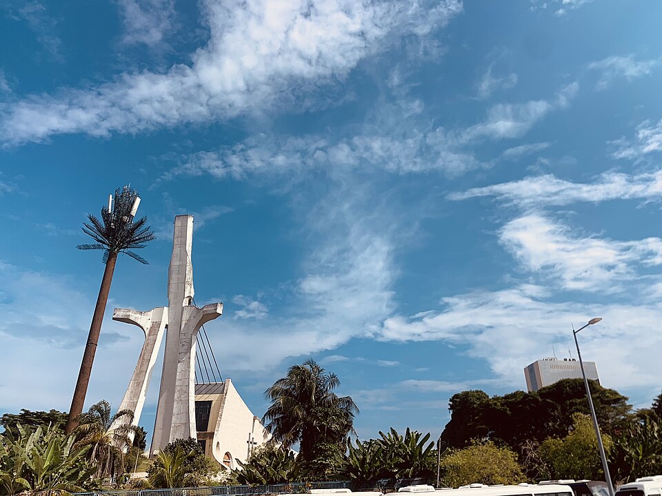 Torre blanca inclinada de la Catedral de San Pablo de Abiyán entre palmeras