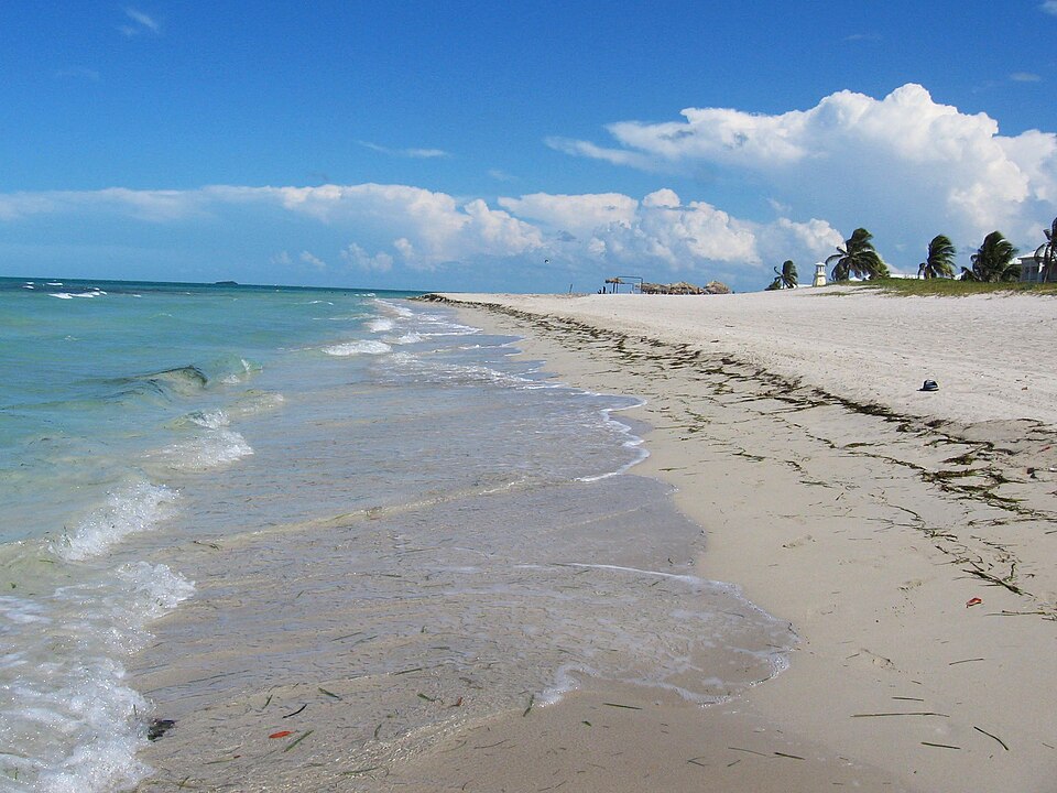 La playa de arena blanca y agua turquesa de Varadero, con palmeras al fondo