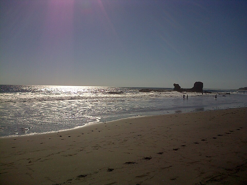 La playa de El Tunco al atardecer, con su gran roca en el mar