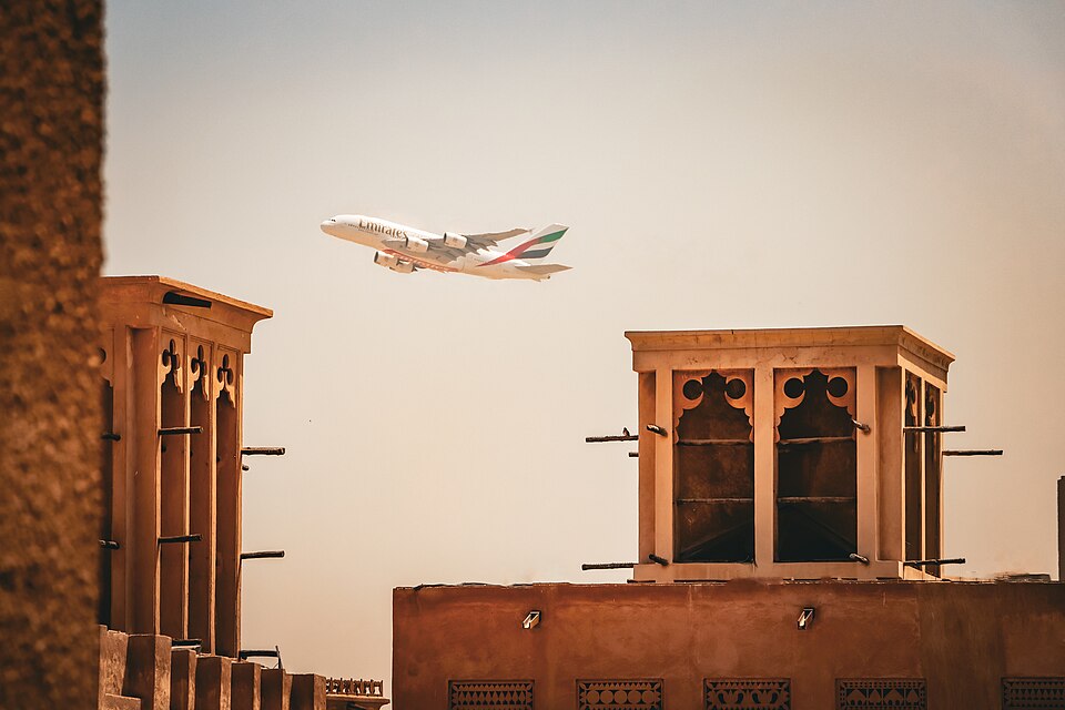 Torres de viento de Al Fahidi con un avión pasando en el cielo