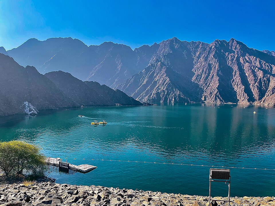 El lago turquesa de la presa de Hatta rodeado de montañas