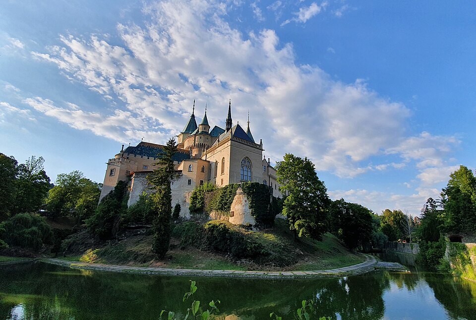 El castillo de Bojnice con sus torres junto a un estanque