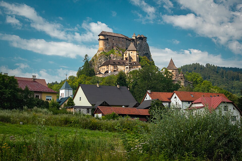 El castillo de Orava sobre una roca, con casas al pie