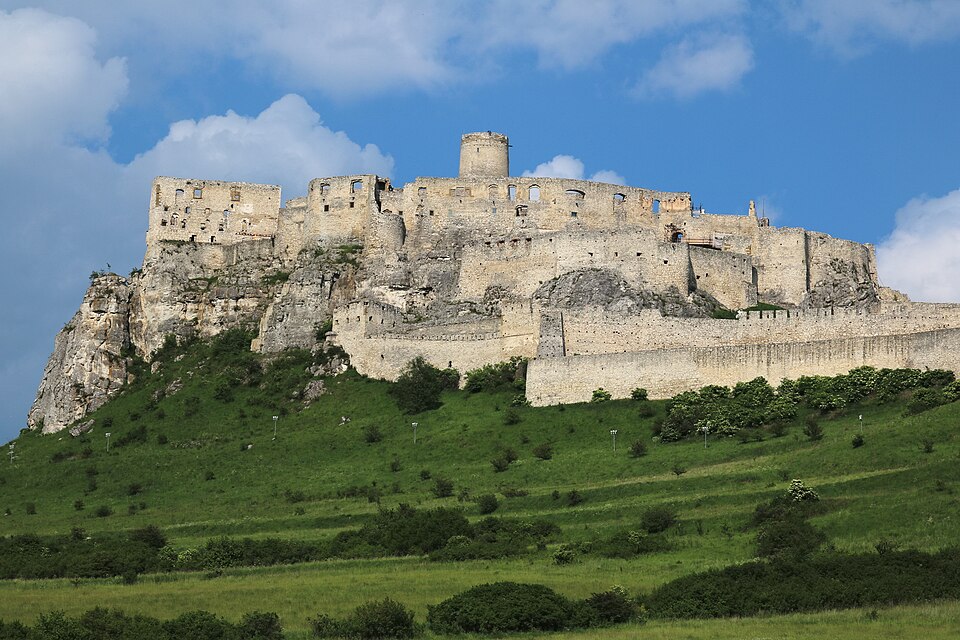 Las ruinas blancas del castillo de Spiš sobre una colina verde