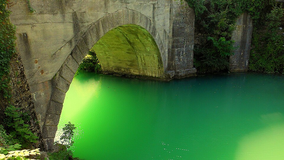 El agua verde esmeralda del río Soča bajo un puente de piedra