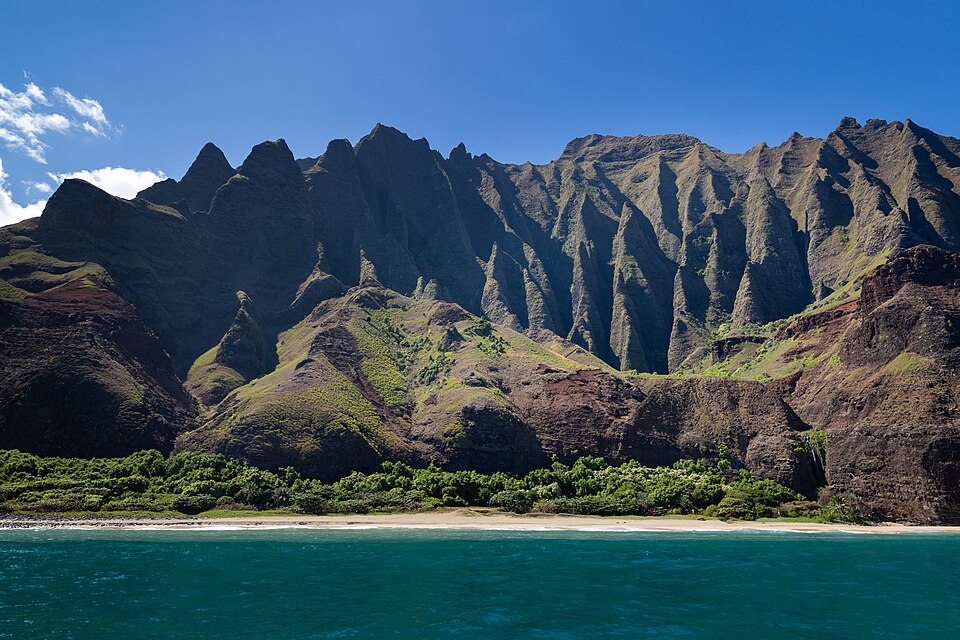 Acantilados verdes de la costa de Nā Pali sobre el mar azul en Kauai