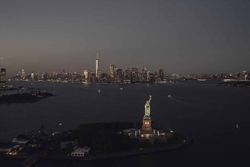 La Estatua de la Libertad frente a los rascacielos de Manhattan al anochecer