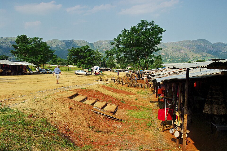 Puestos de un mercado de artesanía en el valle de Ezulwini con montañas al fondo