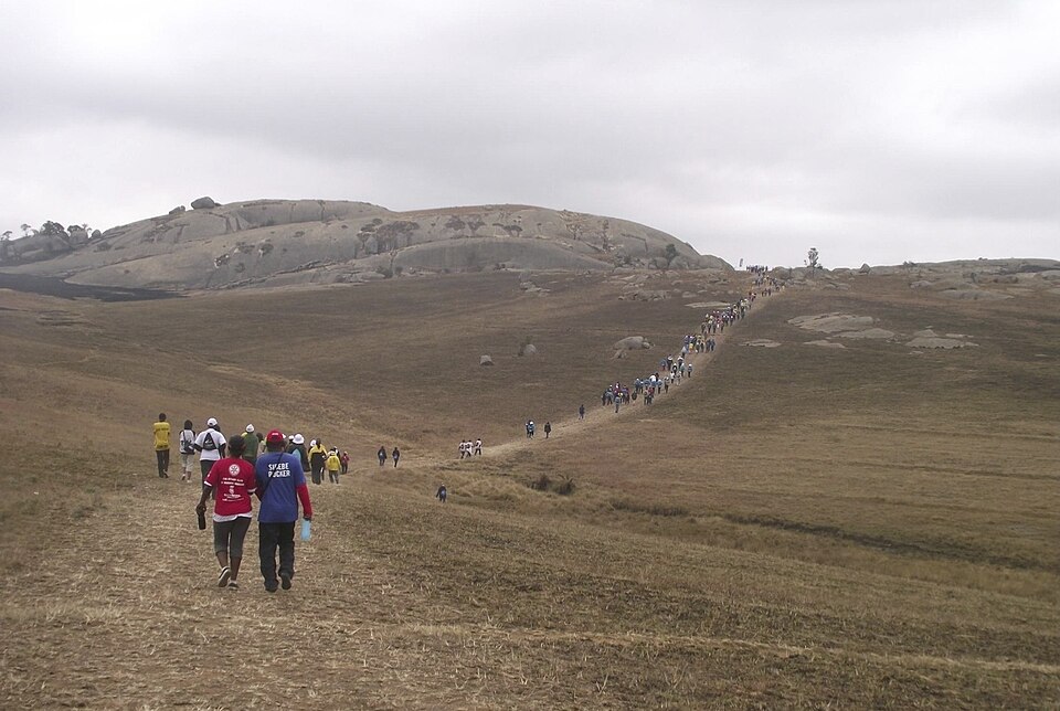 Personas subiendo por la ladera hacia la cima de granito de Sibebe