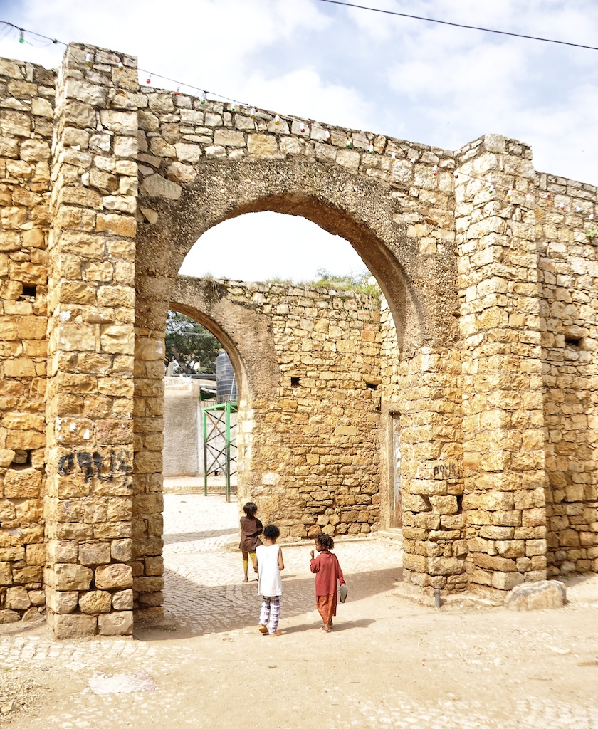 Puerta de piedra de la muralla de Harar con niños caminando